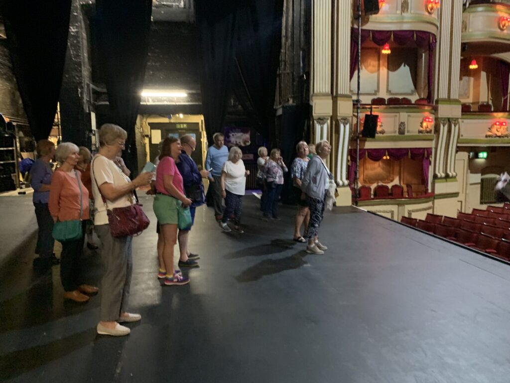 Members on stage during a backstage tour of the Theatre Royal Brighton